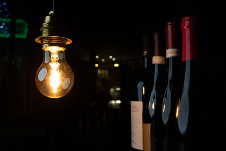 A light bub in a wine cellar with wine bottles